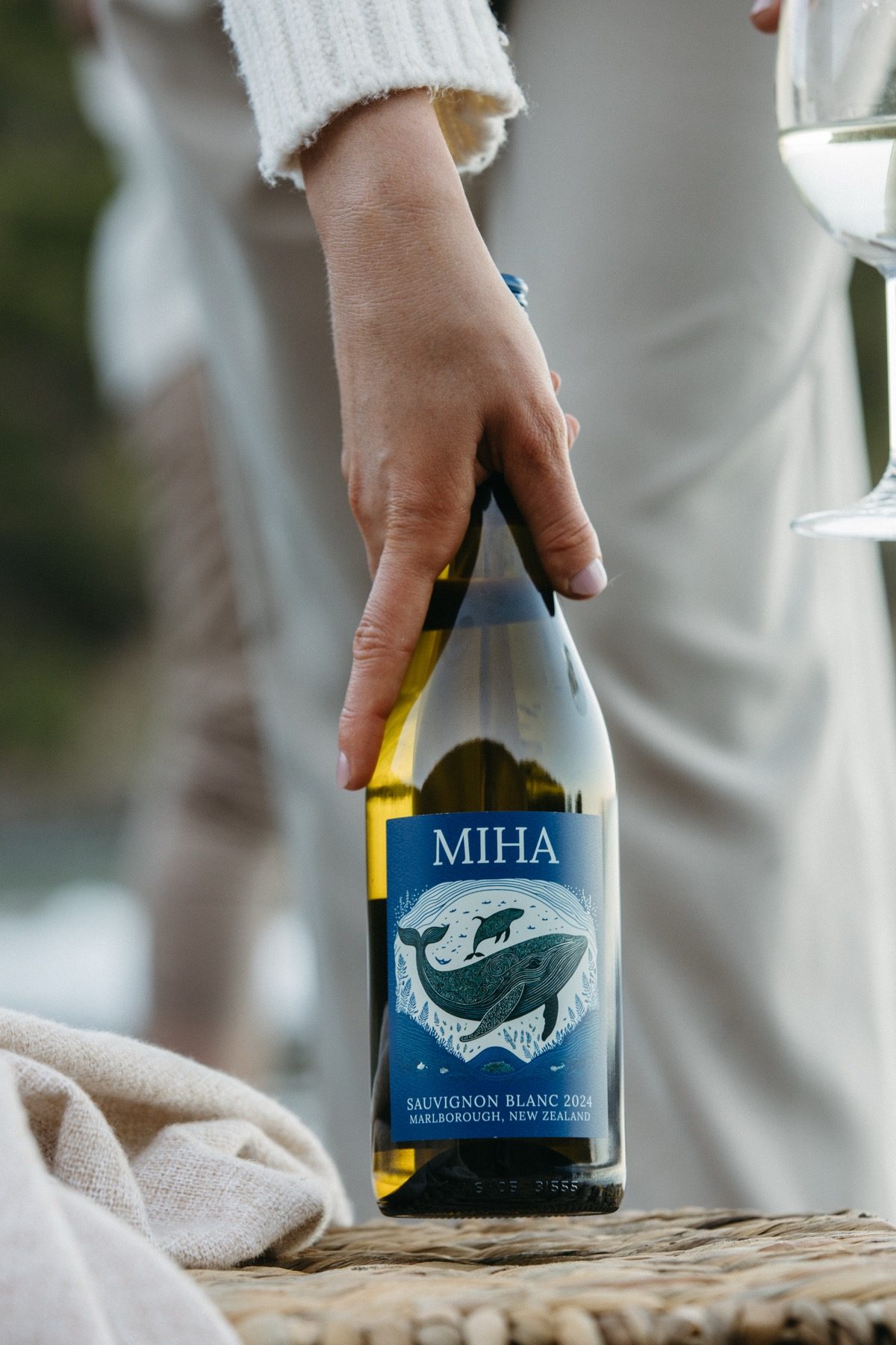 MIHA bottle being held next to a glass